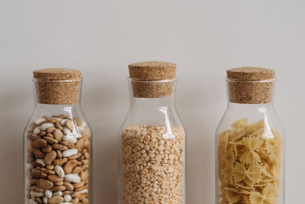 Cork topped glass jars filled with beans, chickpeas and pasta